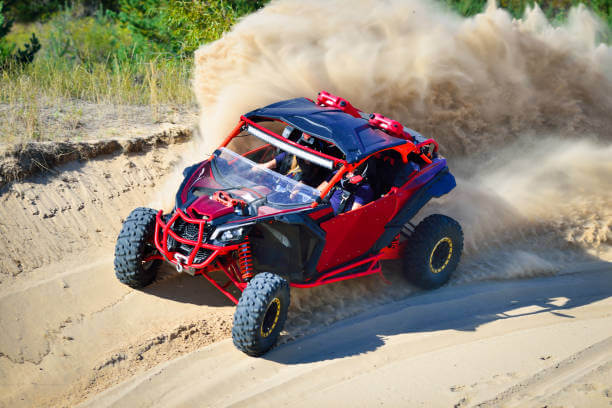 Off-road UTV side-by-side riding in the sand dunes with extended warranty coverage